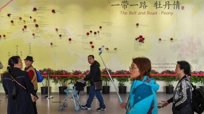 In this file photo, visitors walk past a wall with a map showing the Belt and Road Initiative (BRI) countries, at an exhibition in Beijing, (REUTERS) In this file photo, visitors walk past a wall with a map showing the Belt and Road Initiative (BRI) countries, at an exhibition in Beijing, (REUTERS)
