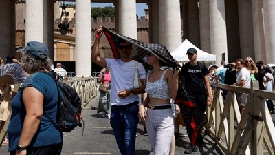 People shelter from the sun as they queue to enter the Saint Peter's Basilica square during a heatwave across Italy, in Vatican. (REUTERS)