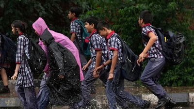 School students walk through a waterlogged road during rain, in New Delhi. (PTI file) School students walk through a waterlogged road during rain, in New Delhi. (PTI file)