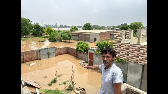 Balvir Singh shows his house submerged in floodwater.