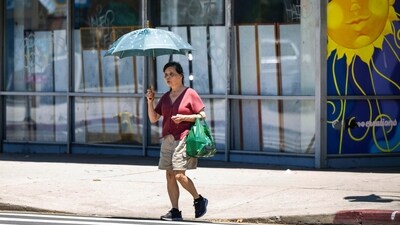 A woman finds shade in the midday heat from a parasol in North Hollywood, California on Wednesday, as a heatwave continues. (AP) A woman finds shade in the midday heat from a parasol in North Hollywood, California on Wednesday, as a heatwave continues. (AP)