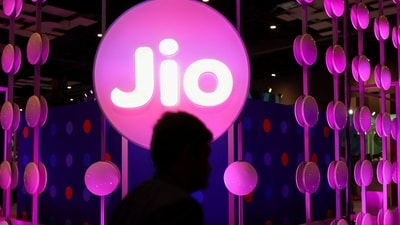 A man walks across the LED board showing the logo of Jio (REUTERS)