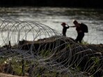 Migrants walk along concertina wire as they try to cross the Rio Grande at the Texas-U.S. border in Eagle Pass, Texas, Thursday, July 6, 2023. (AP Photo/Eric Gay) Migrants walk along concertina wire as they try to cross the Rio Grande at the Texas-U.S. border in Eagle Pass, Texas, Thursday, July 6, 2023. (AP Photo/Eric Gay)