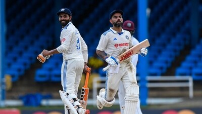 Ravindra Jadeja (L) and Virat Kohli (R), of India, celebrate their 100 runs partnership on the first day of the second Test cricket match between India and West Indies (AFP)