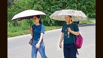 Girls taking cover umbrellas amid the searing heat in Chandigarh on Friday. (Keshav Singh/HT)