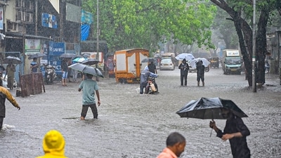 People wade through a waterlogged road amid monsoon rains at Andheri, in Mumbai, Friday. Motorists and pedestrians were severely inconvenienced as the Andheri subway was closed for traffic due to waterlogging. (PTI) People wade through a waterlogged road amid monsoon rains at Andheri, in Mumbai, Friday. Motorists and pedestrians were severely inconvenienced as the Andheri subway was closed for traffic due to waterlogging. (PTI)