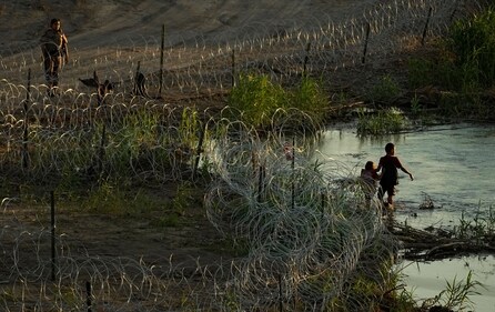 Migrants walk along concertina wire as they try to cross the Rio Grande at the Texas-U.S. border in Eagle Pass, Texas, Thursday, July 6, 2023. (AP Photo/Eric Gay) (AP) Migrants walk along concertina wire as they try to cross the Rio Grande at the Texas-U.S. border in Eagle Pass, Texas, Thursday, July 6, 2023. (AP Photo/Eric Gay) (AP)