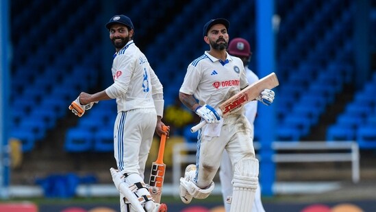 Ravindra Jadeja (L) and Virat Kohli (R), of India, celebrate their 100 runs partnership on the first day of the second Test cricket match between India and West Indies (AFP)