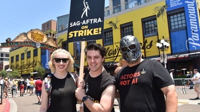Actors (L-R) Aimee La Joie, Sidney Franklin, Mike Egbert hold a strike sign as they demonstrate during San Diego Comic-Con International in San Diego, California, on July 21, 2023. (AFP)