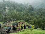 National Disaster Response Force (NDRF) personnel and other volunteers climb up a mountain to reach the site of a landslide at a village in Raigad.