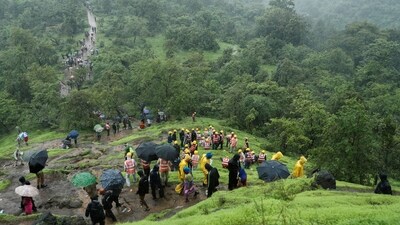National Disaster Response Force (NDRF) personnel and other volunteers climb up a mountain to reach the site of a landslide at a village in Raigad. (REUTERS)