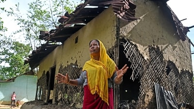 The mother of an accused in the viral sexual assault video case in front of her partially charred house in Pechi Awang Leikai village of the Thoubal district of Manipur. (AFP) The mother of an accused in the viral sexual assault video case in front of her partially charred house in Pechi Awang Leikai village of the Thoubal district of Manipur. (AFP)