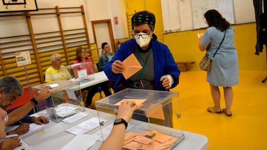 A woman casts her ballot at a polling station in Pamplona, Spain, (AP)