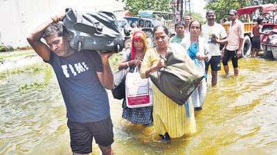 People leave their flooded homes with their belongings in Karhera in Sahibabad, Ghaziabad on Monday. (Sakib Ali/HT Photo)