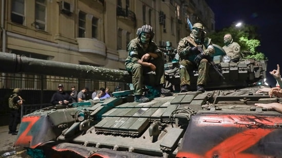 Membes of the Wagner Group military company sit atop of a tank on a street in Rostov-on-Don. (AP)