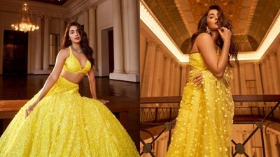 Pooja embraced the summer yellow in these two gorgeous outfits - a sequinned bralette-lehenga set and a net saree embroidered with shimmering paillettes. While a choker necklace and a statement ring glammed up the lehenga, Pooja chose a paillette-embroidered bustier blouse and pearl-adorned jhumkis to complete the six yards. (Instagram/@poojahegde) Pooja embraced the summer yellow in these two gorgeous outfits - a sequinned bralette-lehenga set and a net saree embroidered with shimmering paillettes. While a choker necklace and a statement ring glammed up the lehenga, Pooja chose a paillette-embroidered bustier blouse and pearl-adorned jhumkis to complete the six yards. (Instagram/@poojahegde)