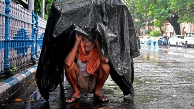 A man takes shelter under a plastic sheet to protect himself during rainfall in Kolkata on Tuesday. (AFP) A man takes shelter under a plastic sheet to protect himself during rainfall in Kolkata on Tuesday. (AFP)