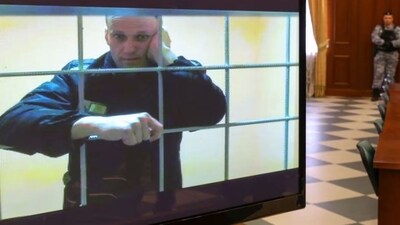 Russian opposition leader Alexei Navalny is seen on a screen via a video link from the IK-2 corrective penal colony in Pokrov during a court hearing to consider an appeal against his prison sentence in Moscow, Russia (Reuters)
