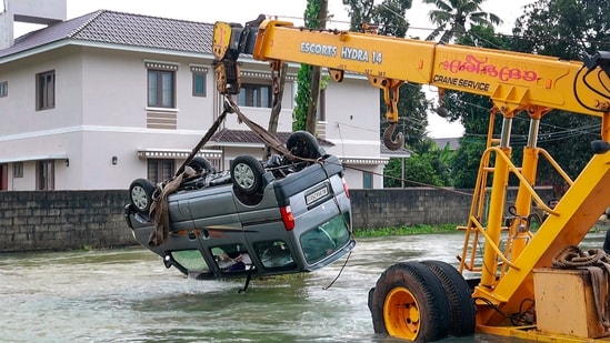 A crane pulls out a vehicle swept away in floods after heavy monsoon rains, in Kottayam. (PTI file)