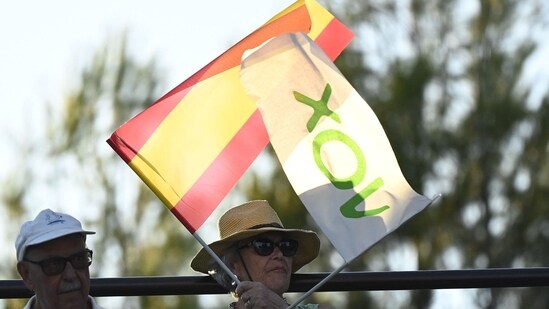 A supporter waves Vox's and Spain's flags as Spanish far-right party Vox' leader Santiago Abascal speaks during a campaign meeting in Guadalajara on July 15, 2023 ahead of July 23 general election. (Photo by OSCAR DEL POZO / AFP)