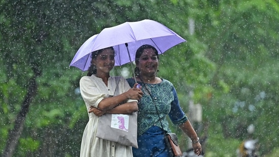 Women use an umbrella to protect themselves amid rainfall in Chennai on July 25, 2023. (Photo by R.Satish BABU / AFP) Women use an umbrella to protect themselves amid rainfall in Chennai on July 25, 2023. (Photo by R.Satish BABU / AFP)