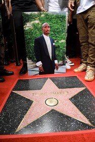 FILE PHOTO: A person holds a picture of Rapper Tupac Shakur next to his star during its posthumous unveiling ceremony on the Hollywood Walk of Fame in Los Angeles, California, U.S. June 7, 2023. REUTERS/Mario Anzuoni/File Photo (REUTERS)