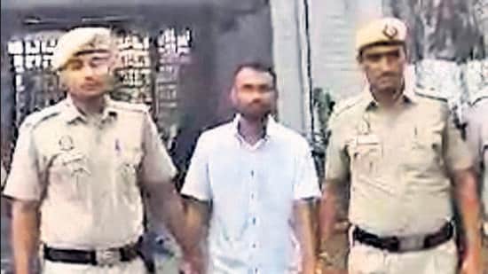 Police with Deepak. After committing the murder, Deepak dragged his mother Indu’s body to the other room, switched on the AC, and slept for the next six hours, deputy commissioner of police (north) Sagar Singh Kalsi said. (HT Photo)