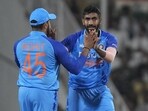 India's Jasprit Bumrah, right, celebrates with captain Rohit Sharma after the dismissal of Australia's captain Aaron Finch
