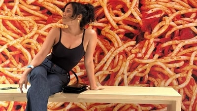 Masaba Gupta posed inside the quirky and playful exhibition, Run As Slow As You Can, in one of the pictures. She sat in front of a giant poster of what appeared to be spaghetti. The actor and fashion designer was dressed in a black tank top and a pair of blue denims. Masaba Gupta posed inside the quirky and playful exhibition, Run As Slow As You Can, in one of the pictures. She sat in front of a giant poster of what appeared to be spaghetti. The actor and fashion designer was dressed in a black tank top and a pair of blue denims. 