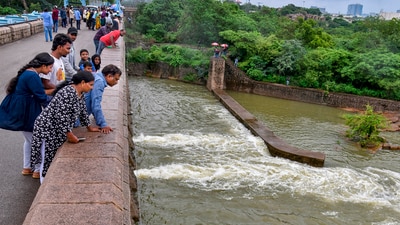 People watch the opening of Osman Sagar (Gandipet) flood gates to release excess water to Moosi River by Hyderabad Metro Works & Sewerage department, (PTI) People watch the opening of Osman Sagar (Gandipet) flood gates to release excess water to Moosi River by Hyderabad Metro Works & Sewerage department, (PTI)