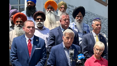 New York state assemblyman David Weprin, bottom centre, joined by members of the Sikh community, speaking during a news conference addressing dress codes within the state police, in New York. (AP)