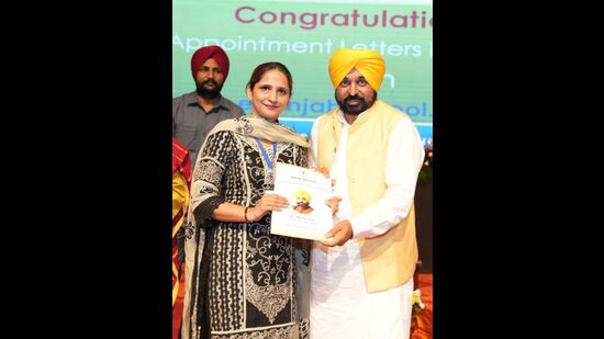 CM Bhagwant Mann handing over regularisation letter to a teacher in Chandigarh on Friday. (HT Photo)