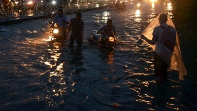 Commuters wade through the waterlogged Delhi-Gurugram Expressway and its service road amid heavy rains in Gurugram on Friday. (ANI) Commuters wade through the waterlogged Delhi-Gurugram Expressway and its service road amid heavy rains in Gurugram on Friday. (ANI)