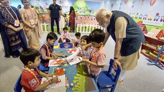 PM Modi interacts with children at the &nbsp;exhibition during the Akhil Bharatiya Shiksha Samagam, at Bharat Mandapam in New Delhi on Saturday.(PTI)