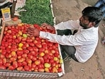 A farmer sells tomatoes in the market.