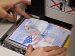 (FILES) A US government official with the State Department's Passport Services places a new blank US Passport with an embedded electronic chip into the "book printer," entering personal data and the photograph of an applicant on June 14, 2007, in Washington, DC.