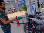 Man pours petrol over his bike.