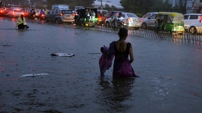 A woman wades through the waterlogged Delhi-Gurugram Expressway amid heavy rains, in Gurugram on Friday. (ANI Photo) A woman wades through the waterlogged Delhi-Gurugram Expressway amid heavy rains, in Gurugram on Friday. (ANI Photo)