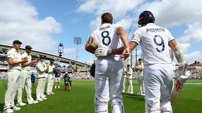England's Stuart Broad is pushed ahead by James Anderson to receive a guard of honour from the Australian players (Reuters)