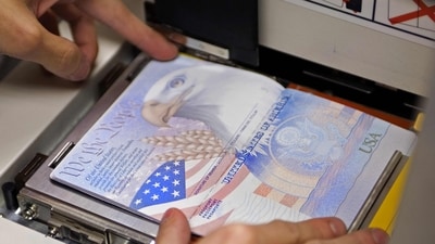 (FILES) A US government official with the State Department's Passport Services places a new blank US Passport with an embedded electronic chip into the "book printer," entering personal data and the photograph of an applicant on June 14, 2007, in Washington, DC. (AFP) (FILES) A US government official with the State Department's Passport Services places a new blank US Passport with an embedded electronic chip into the "book printer," entering personal data and the photograph of an applicant on June 14, 2007, in Washington, DC. (AFP)