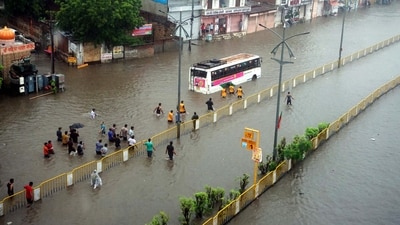 People wade through the waterlogged road after the heavy rains, in Jaipur on Saturday. (ANI Photo) People wade through the waterlogged road after the heavy rains, in Jaipur on Saturday. (ANI Photo)