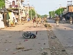 A damaged two-wheeler lies on the road as Police personnel deployed after a clash erupted between two groups in Haryana's Nuh on Monday. A damaged two-wheeler lies on the road as Police personnel deployed after a clash erupted between two groups in Haryana's Nuh on Monday.