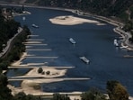 Transport vessels cruise past the partially dried riverbed of the Rhine river in Bingen, Germany.(REUTERS)