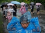 A child wearing a rain cover walks as visitors tour near the closed Forbidden City as a rainstorm soak Beijing, Sunday. A child wearing a rain cover walks as visitors tour near the closed Forbidden City as a rainstorm soak Beijing, Sunday.