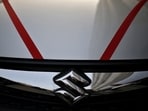 The logo of Maruti Suzuki India Limited is seen on car parked outside a showroom in New Delhi.