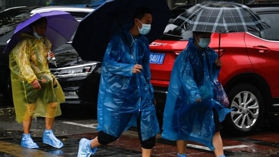 Typhoon Doksuri: People shelter from the rain with umbrellas in Beijing. (AFP) Typhoon Doksuri: People shelter from the rain with umbrellas in Beijing. (AFP)