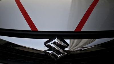 The logo of Maruti Suzuki India Limited is seen on car parked outside a showroom in New Delhi. (REUTERS)