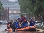 Beijing Rainfall: Rescue workers in a boat go through a flooded street in Beijing.