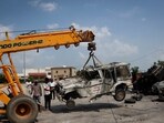 A crane removes a burnt vehicle following clashes between Hindus and Muslims in Nuh district of the northern state of Haryana, India, August 1.