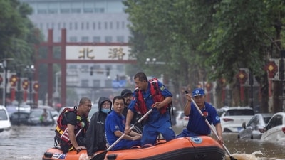 Beijing Rainfall: Rescue workers in a boat go through a flooded street in Beijing. (Reuters)